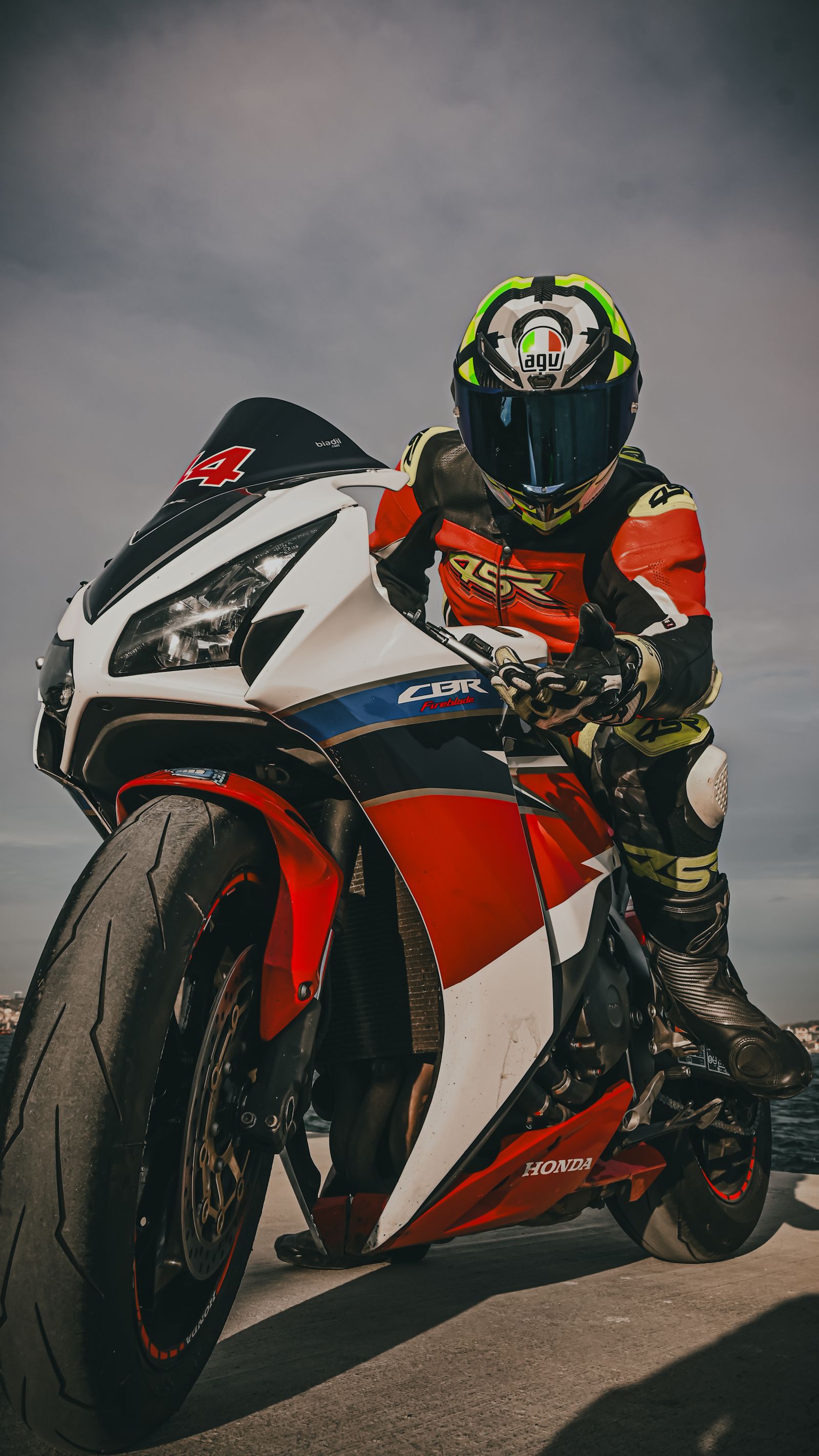 Motard en tenue de protection complète négociant un virage sur une moto de course