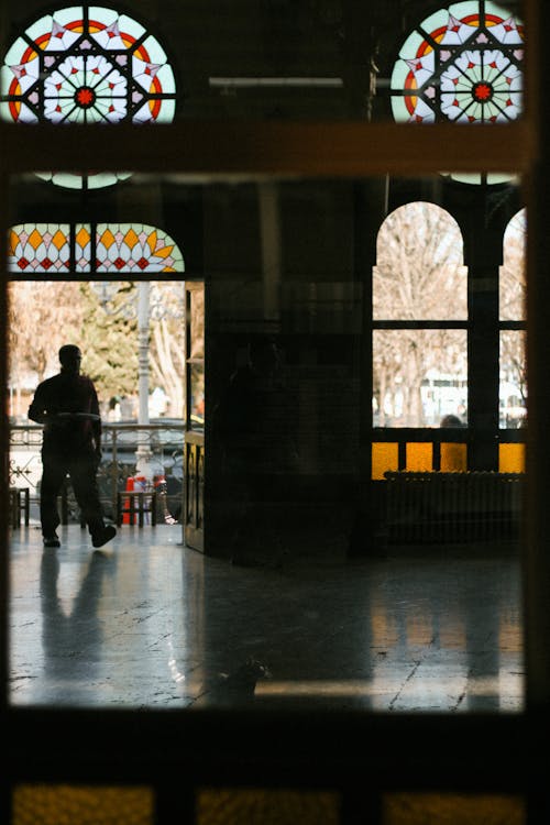 A couple is standing in front of stained glass windows