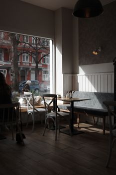 Sunlit cafe with wooden floors and window seating in Hanover, Germany, capturing a serene atmosphere.