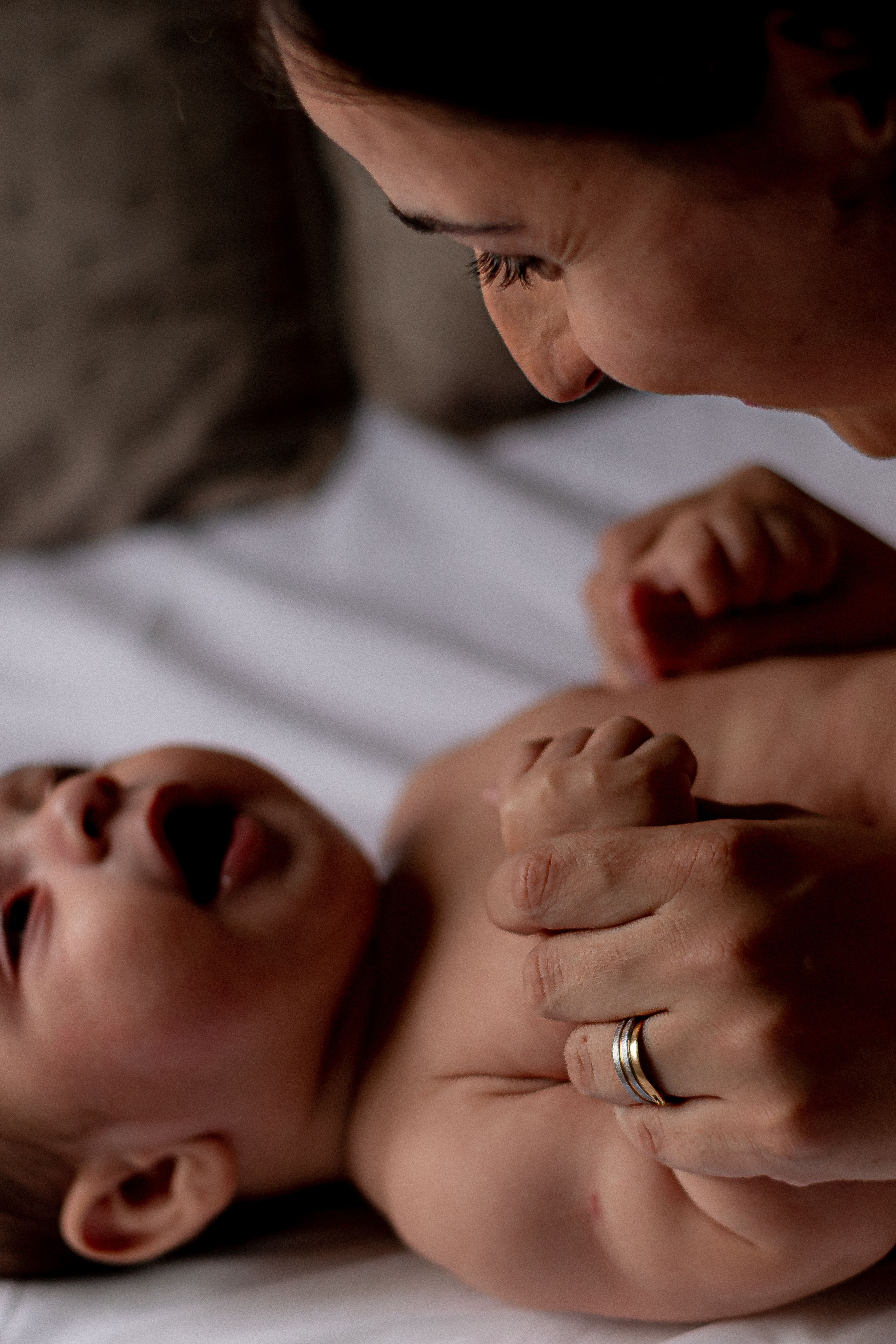 A tender moment captured indoors showcasing a mother and baby bonding intimately.