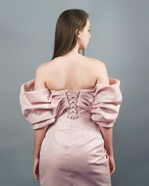 The back view of a woman in a pink dress