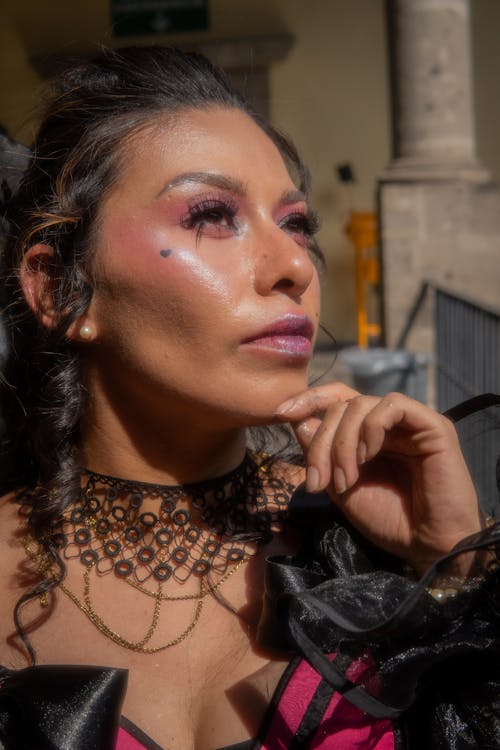 A woman with a pink dress and makeup on