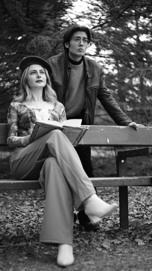 A man and woman sitting on a bench in the woods