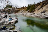 美丽的河流景观中，水流潺潺，岩石河岸与白雪皑皑的树木相映成趣