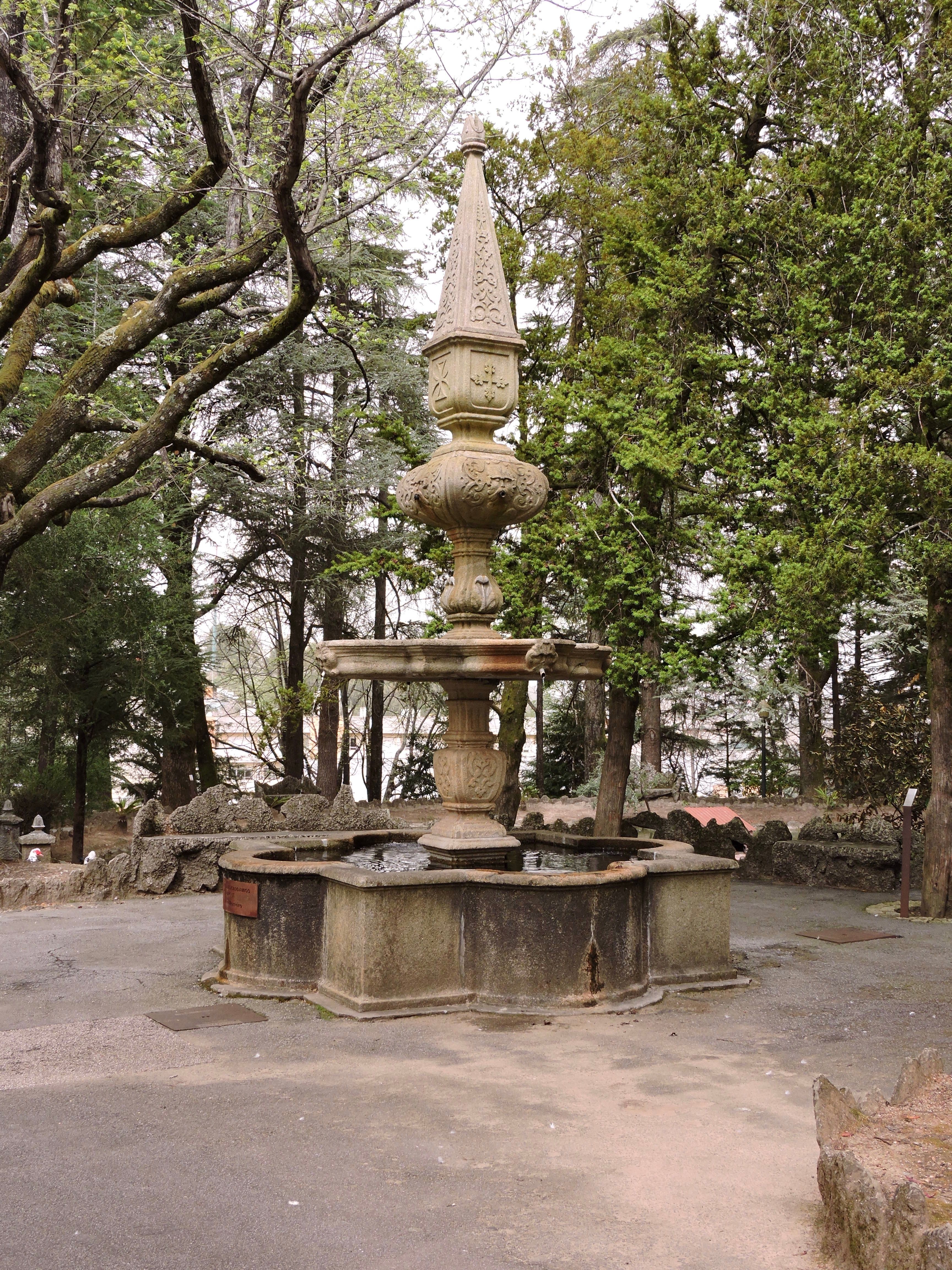 A fountain in the middle of a park with trees · Free Stock Photo