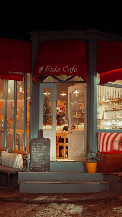 A cafe with a red awning and a sign that says, cafe