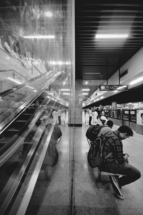 A black and white photo of people waiting in a subway