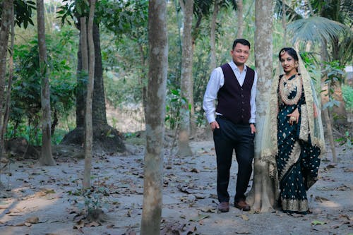 A couple standing in the woods in front of a tree