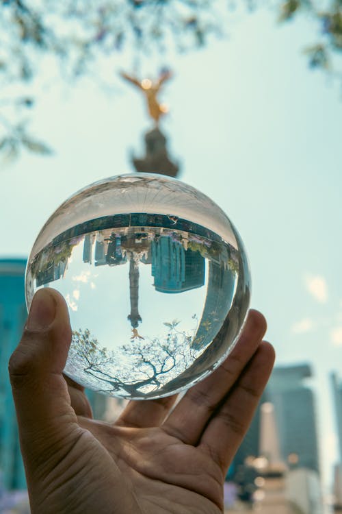 A person holding a crystal ball in front of a city