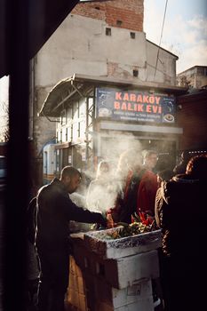 A street vendor sells delicious foods amidst urban backdrop, with steam rising in the evening sun.