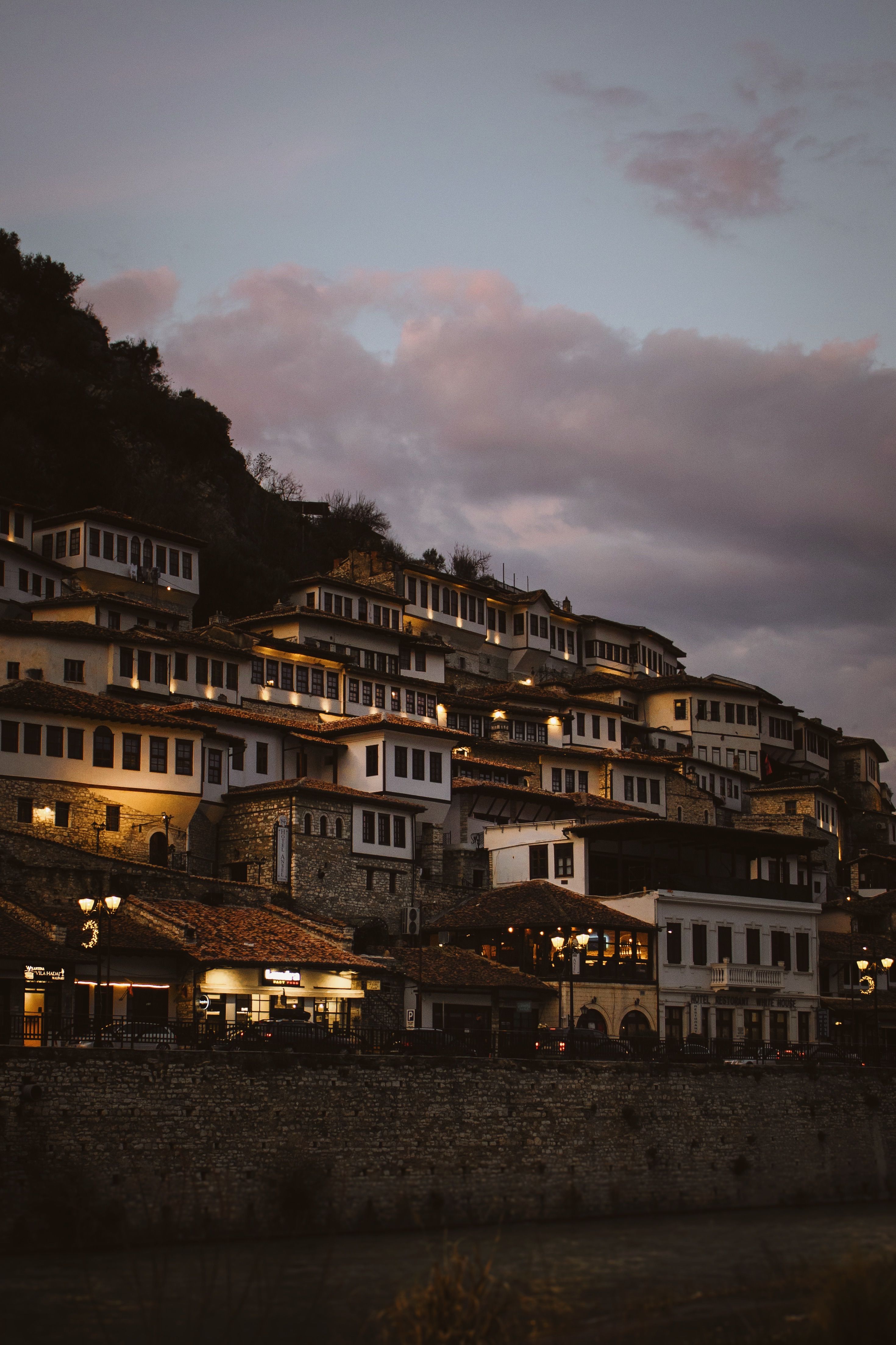 Charming twilight view of Berat, Albania showcasing traditional houses on a hill.