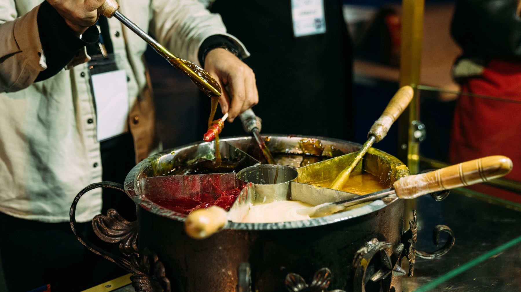 Close-up of hands crafting traditional sweets in an artisan kitchen setting.