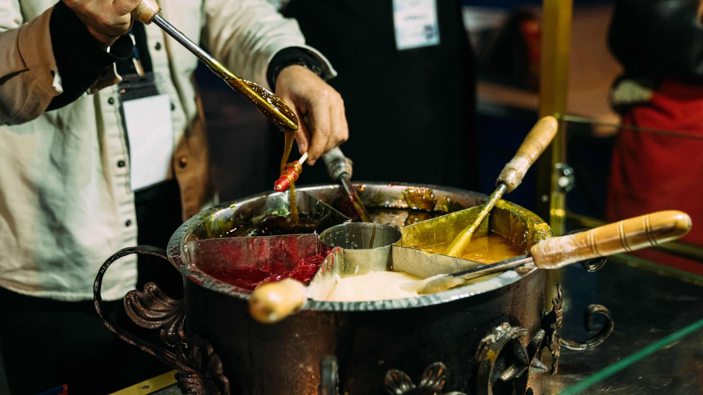 Close-up of hands crafting traditional sweets in an artisan kitchen setting.