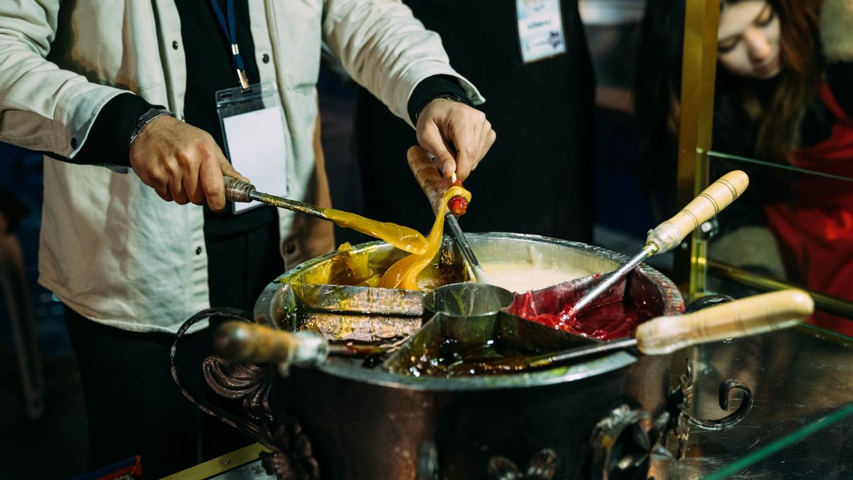 A street vendor crafting colorful traditional Turkish candy at a market stall.