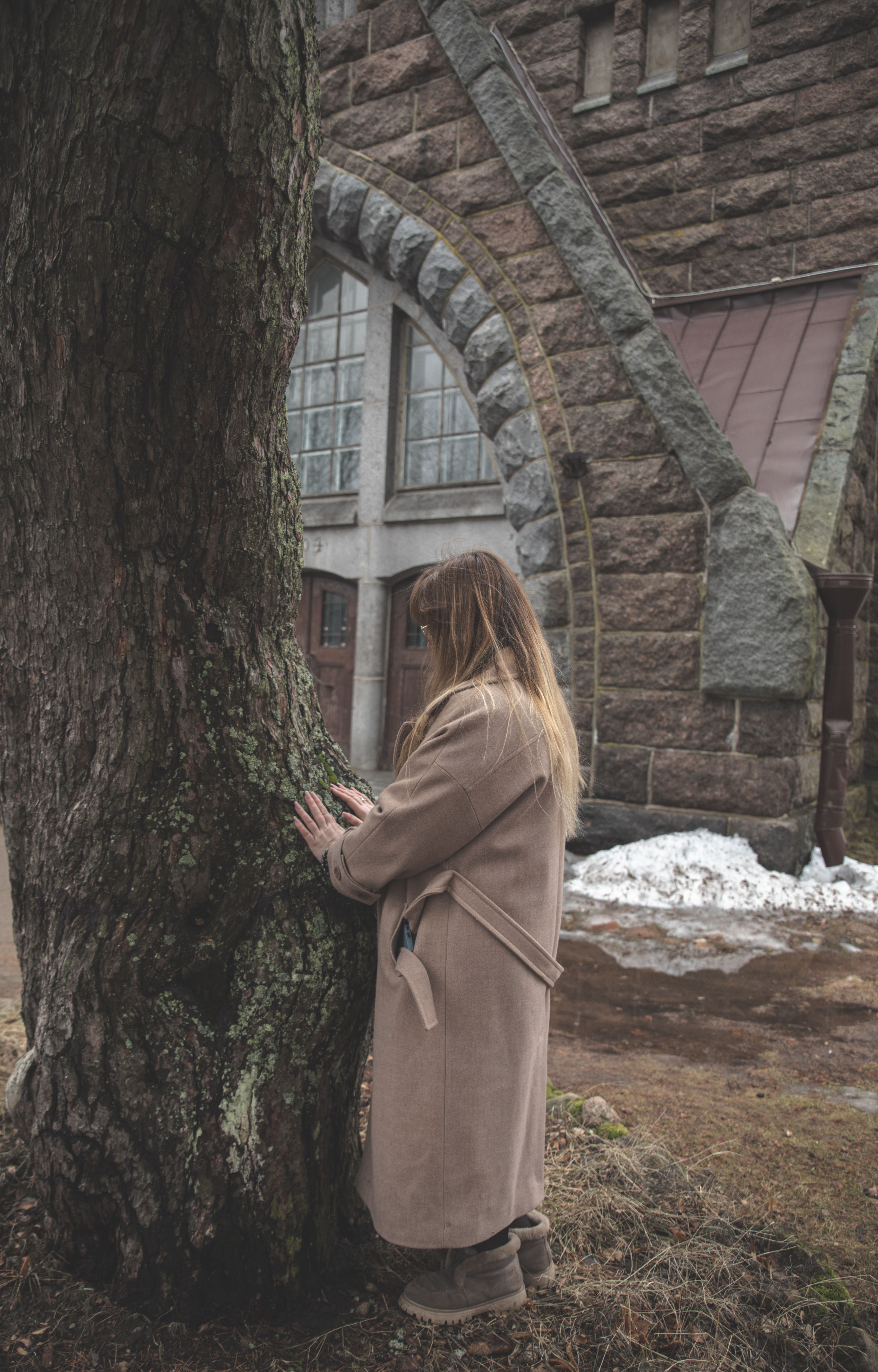 Woman in Coat Standing near Building Wall · Free Stock Photo
