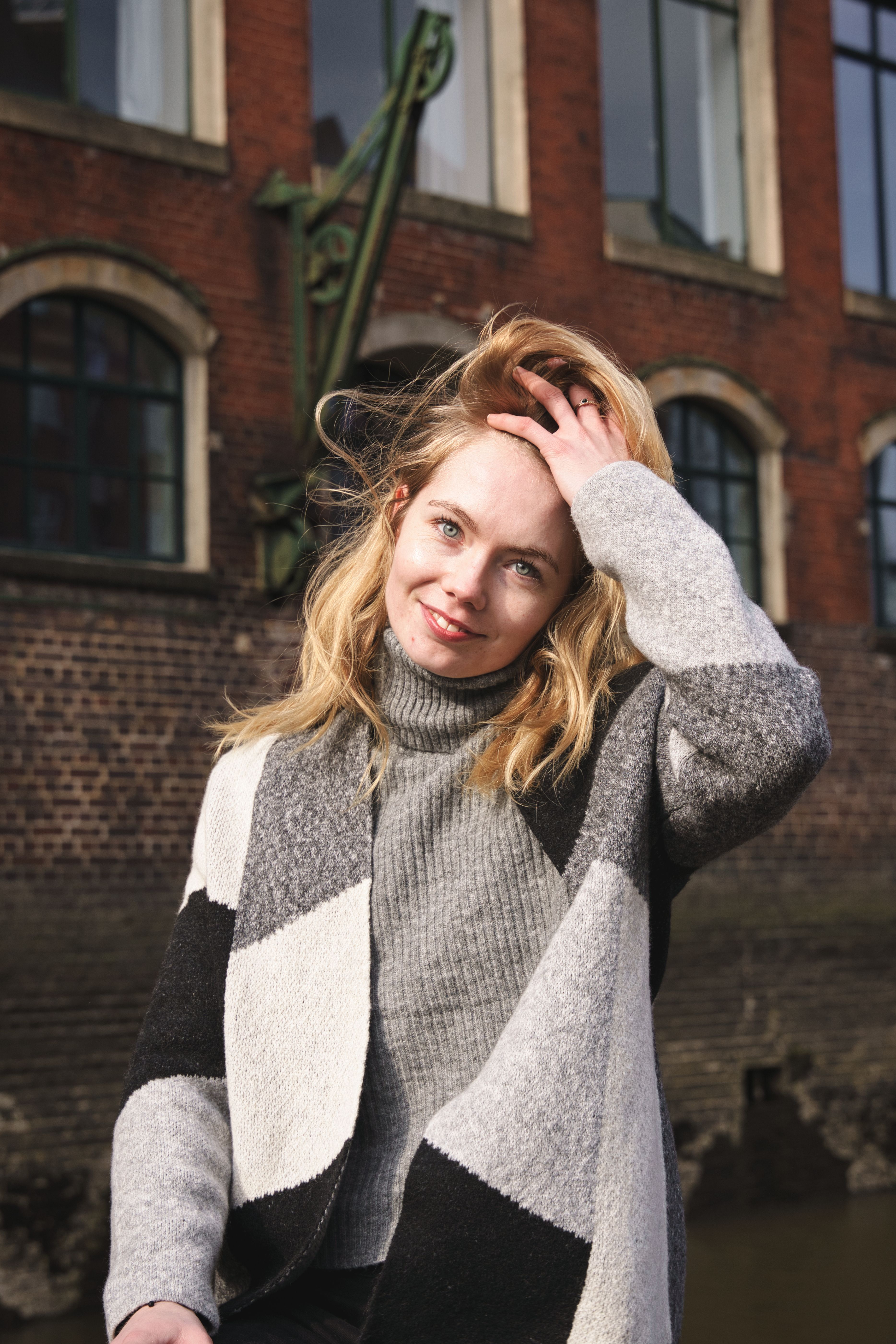 Stylish woman smiling outdoors in urban Hamburg, Germany.
