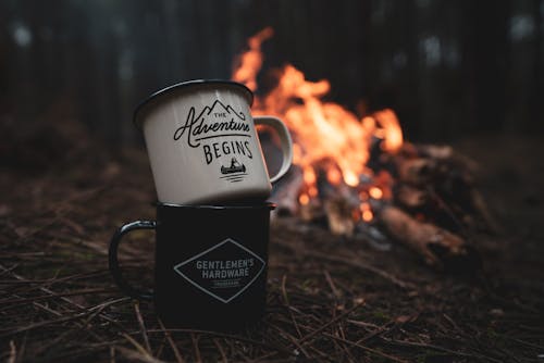 Two mugs sitting on a campfire with the words, 'the best is yet to come'