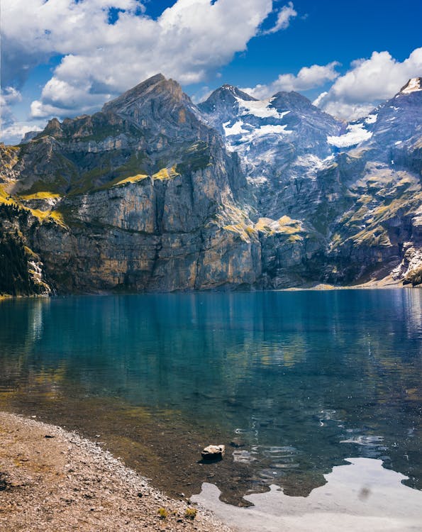 бесплатная Водоем возле горы в пасмурную погоду Стоковое фото