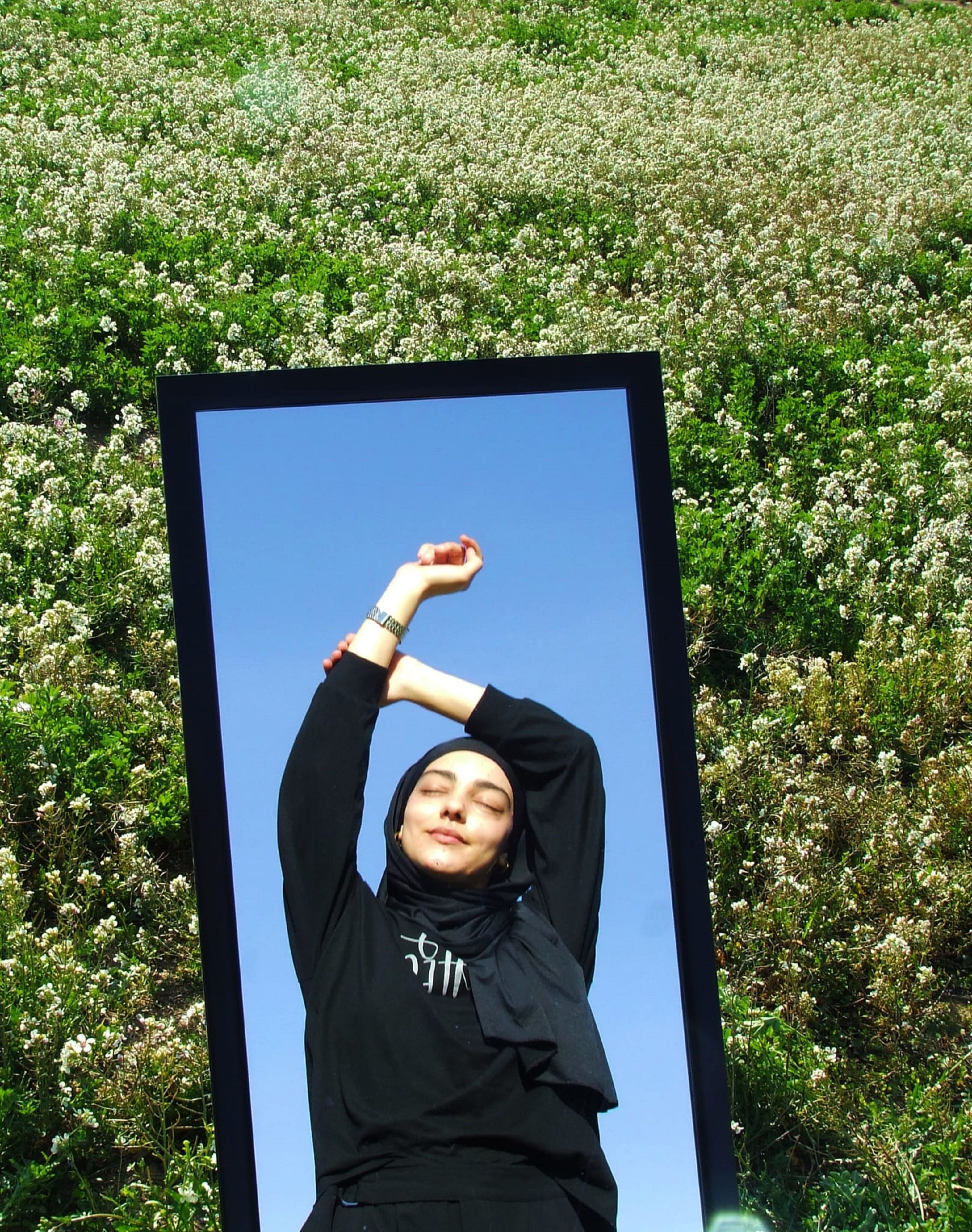 Reflection of Woman in Mirror in Meadow