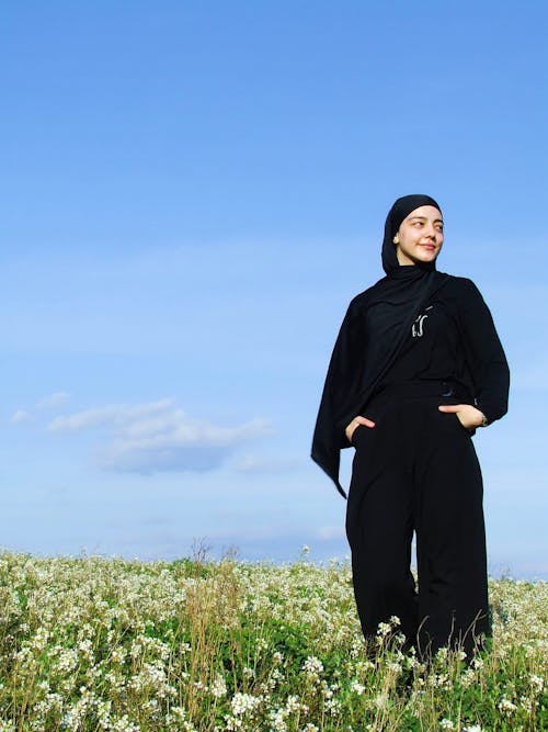 A woman in black standing in a field