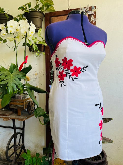 A dress with flowers on it is displayed on a mannequin