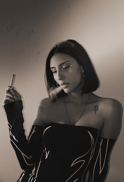 A woman smoking a cigarette in black and white