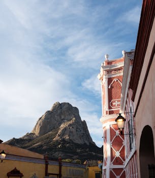 Stunning view of Peña de Bernal rock formation with traditional architecture in Querétaro, Mexico.