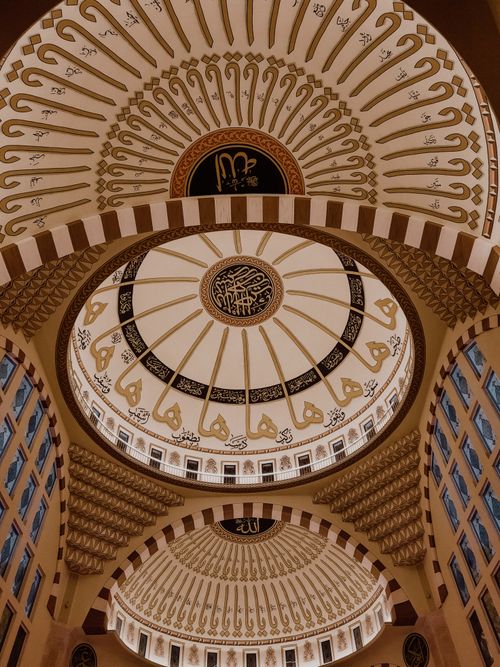 Free Stunning view of an intricately ornamented mosque ceiling with Arabic calligraphy, showcasing Islamic art. Stock Photo