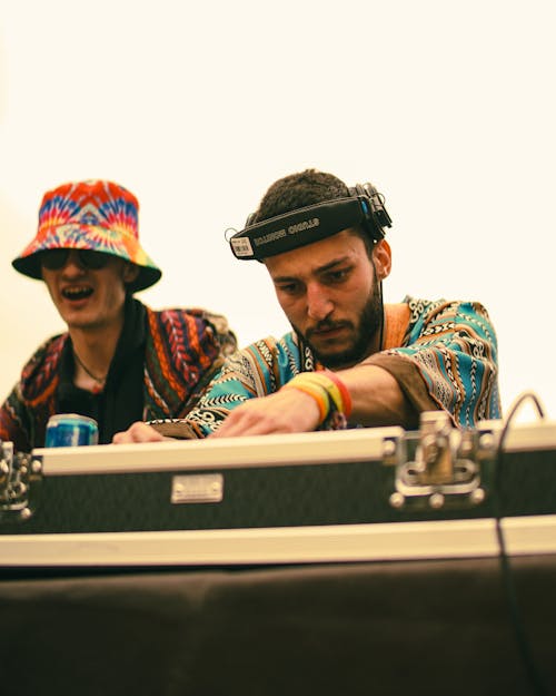 Two men in hats playing music on a keyboard