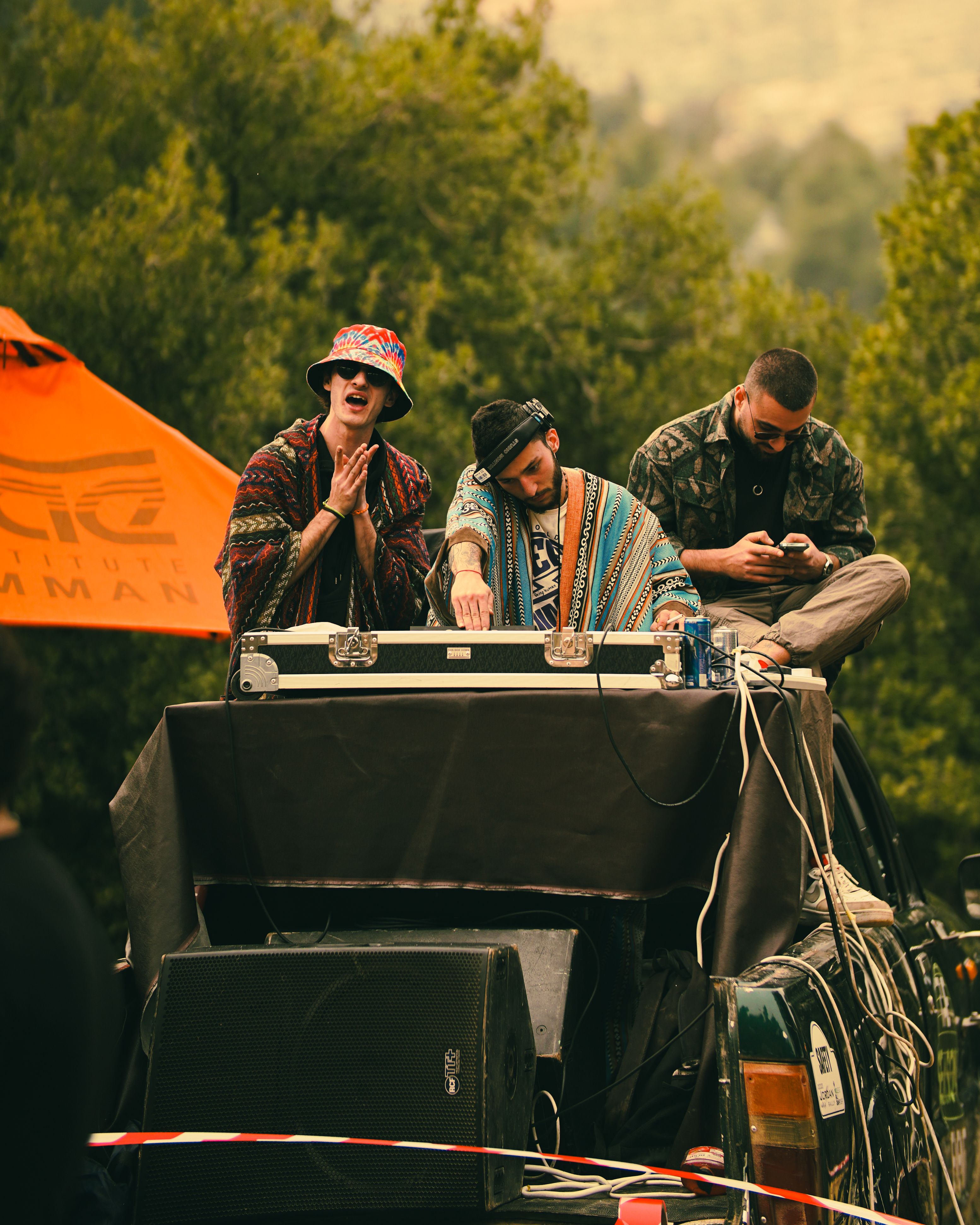 DJs performing live at an outdoor music festival with electronic equipment.