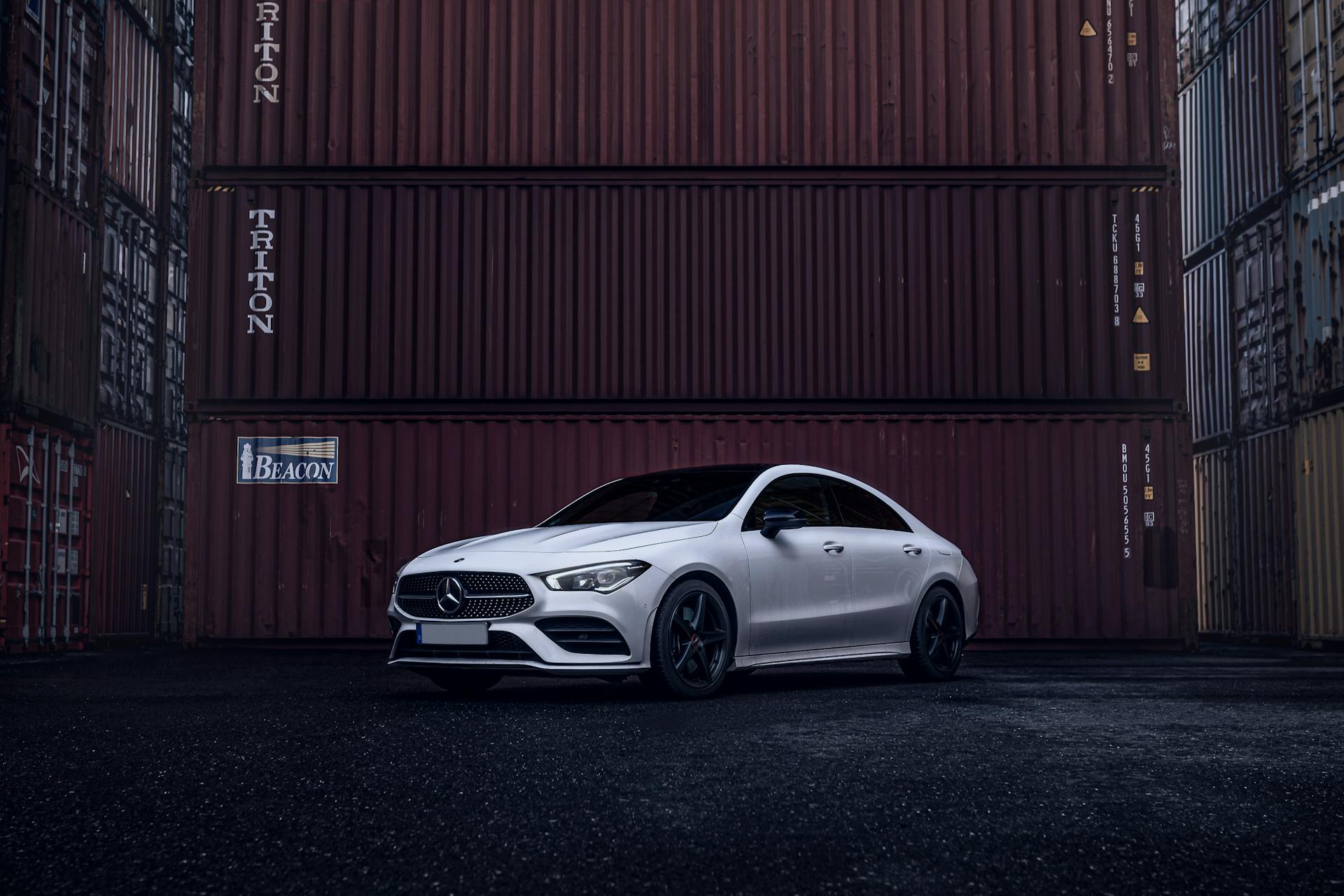 Photo of a Mercedes-Benz CLA Parked next to Containers in a Port