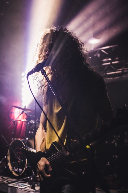Free Dramatic stage shot of a guitarist performing live at a vibrant rock concert. Stock Photo