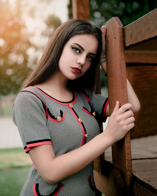 Photo of Woman Leaning On Wooden Fence