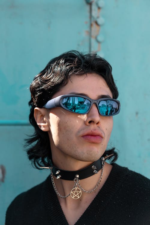A man with a necklace and sunglasses