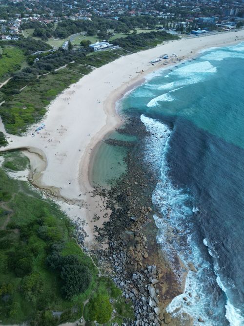 Free Stunning aerial photo capturing a vibrant coastline with sandy beaches and turquoise waves. Stock Photo