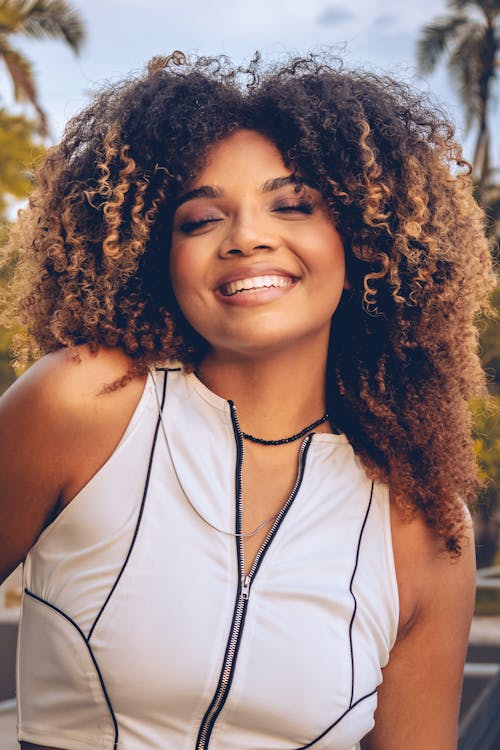 A woman with curly hair smiling and posing for a photo