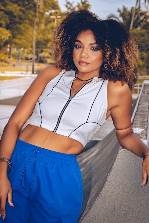 A woman in a crop top and blue pants