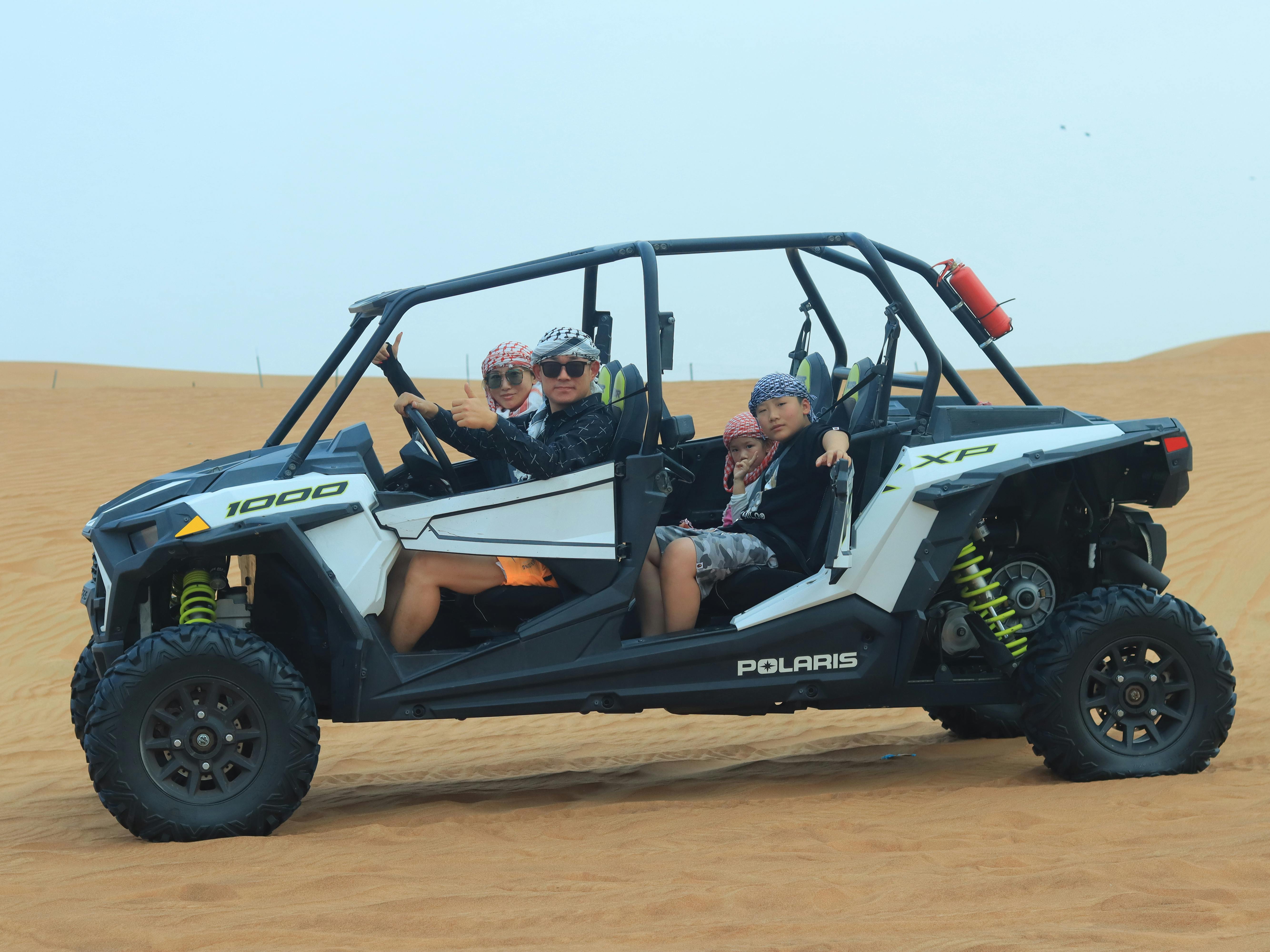 Family exploring Dubai's desert in a buggy, enjoying an adventurous ride together.