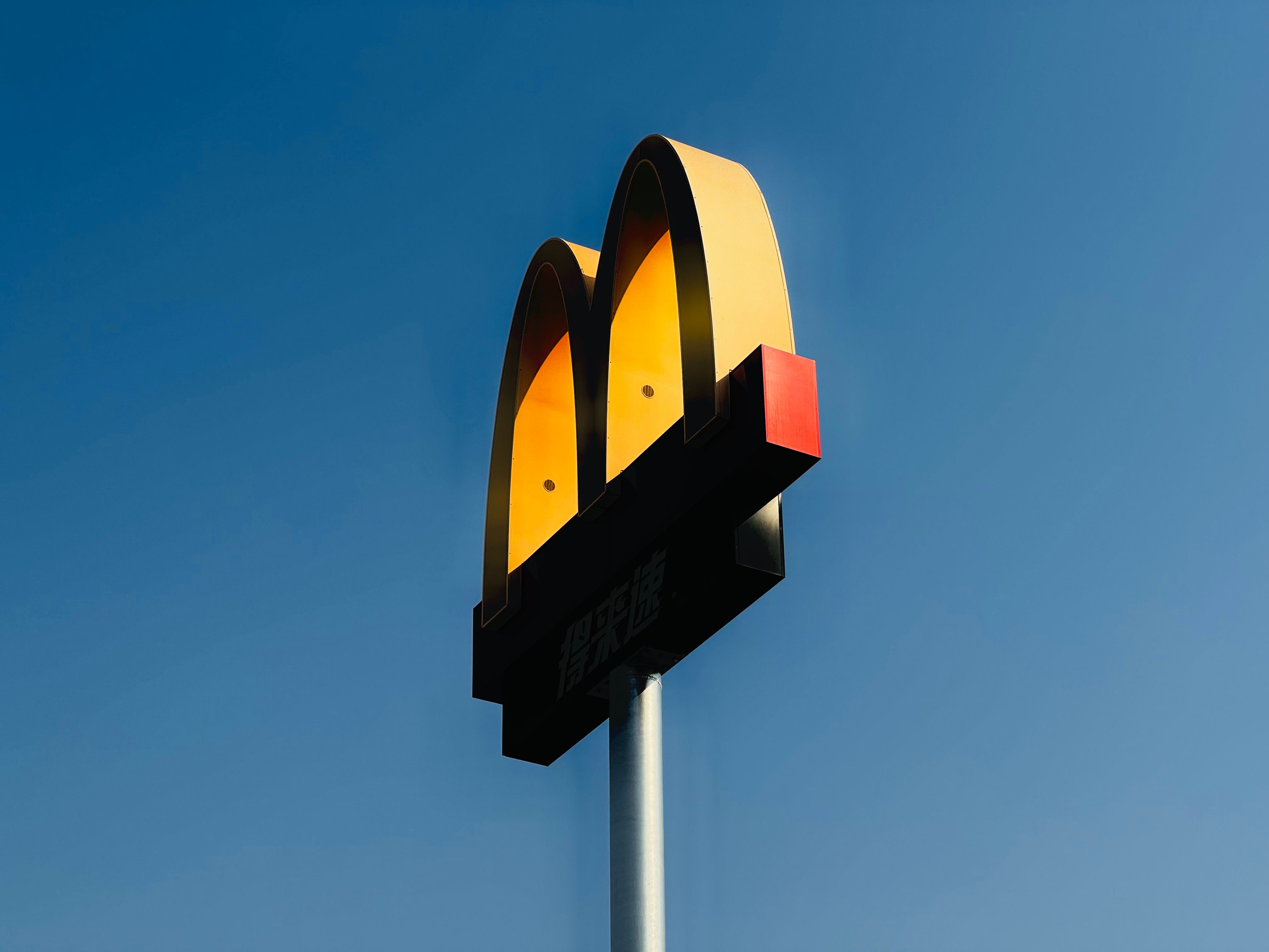 Vibrant McDonald's sign on a clear day in Tianjin, China.