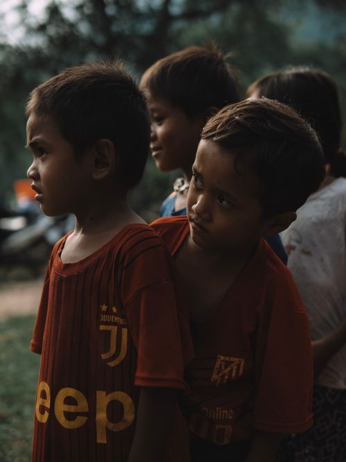 Free Group of young boys wearing sports jerseys standing outdoors, captured in warm morning light. Stock Photo