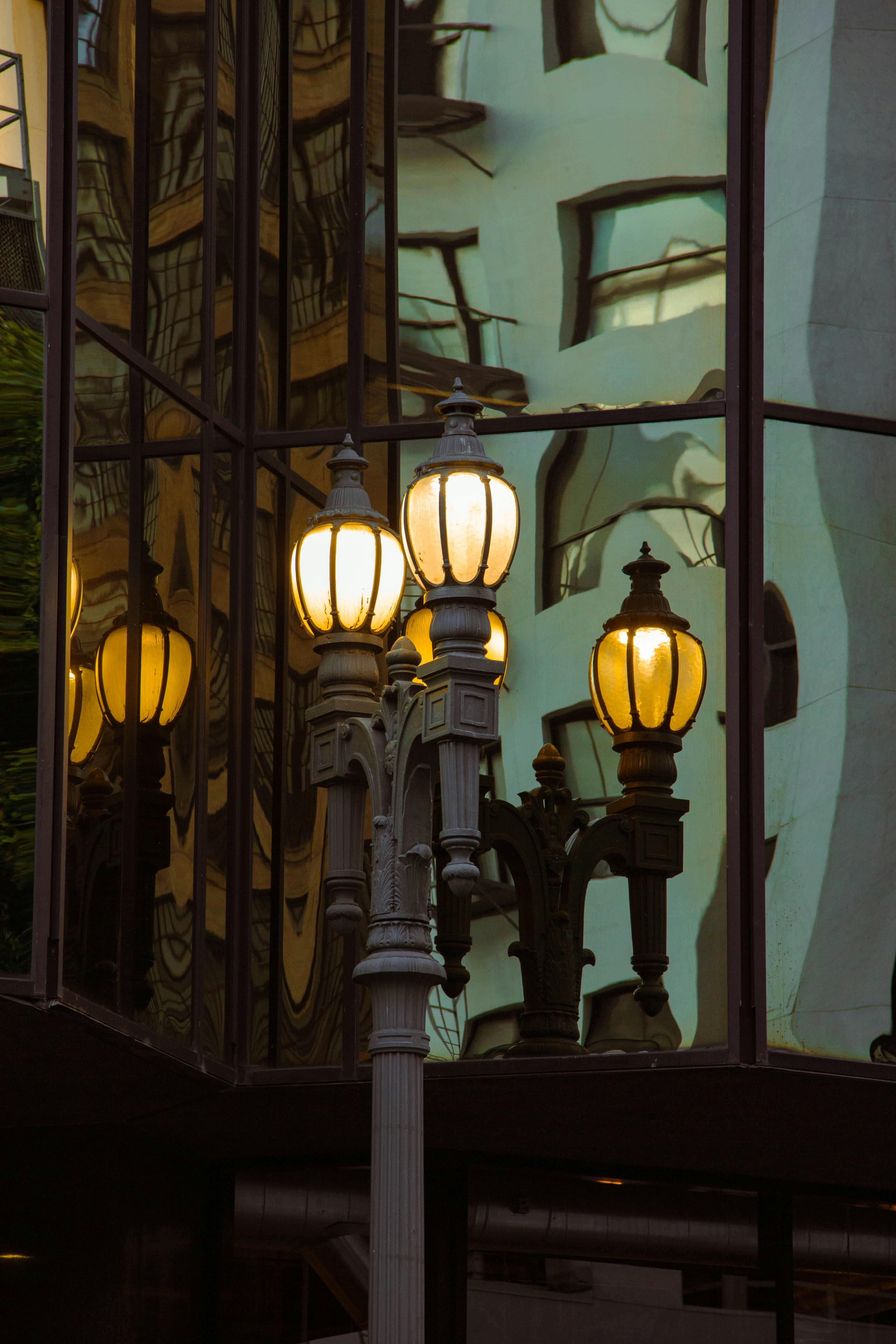 Urban streetlights reflecting in a modern glass building in Los Angeles, creating an artistic visual.