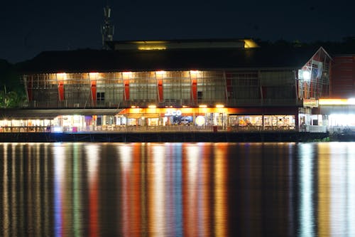 A large building lit up at night with water in the background