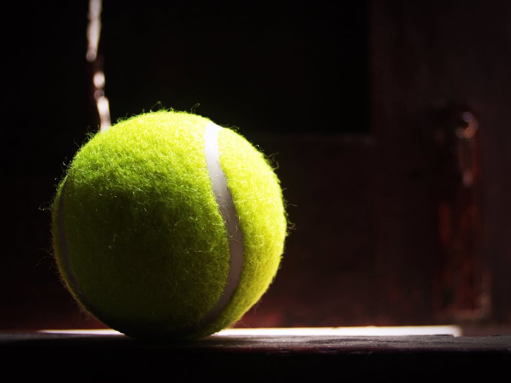 бесплатная Теннисный мяч на зеленой лужайке Стоковое фото