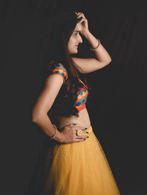 A woman in yellow lehenga posing for the camera