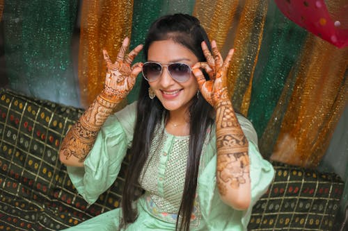 A woman in green dress with henna on her hands