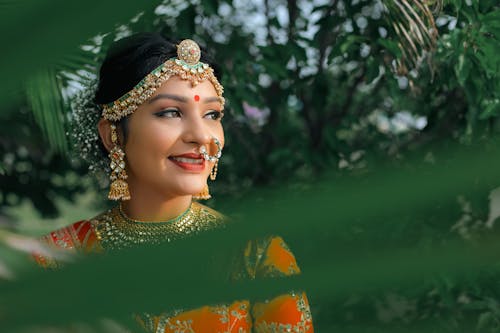 A beautiful indian bride in an orange and gold lehenga