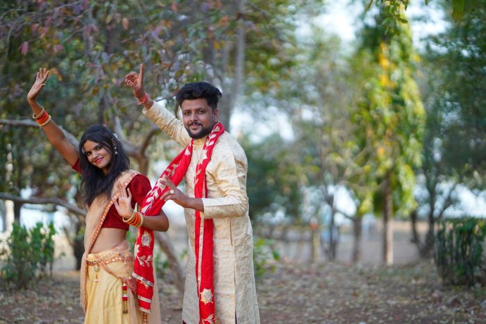 Newlyweds in traditional Indian attire in a forest setting
