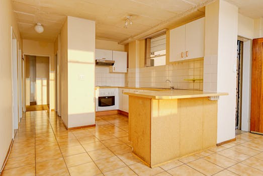 Spacious kitchen featuring modern interior design with tiled floor and ample natural light.