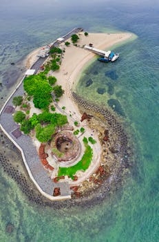 一张东努沙登加拉岛风景优美的历史岛屿航拍照片，其中包含海滩和废墟