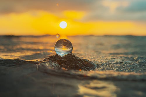 A water droplet on the beach at sunset